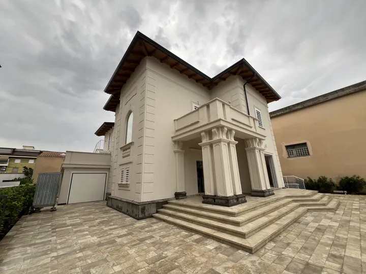 Villa in stile classico con colonne all’ingresso, scalinata e finestre con grate di sicurezza