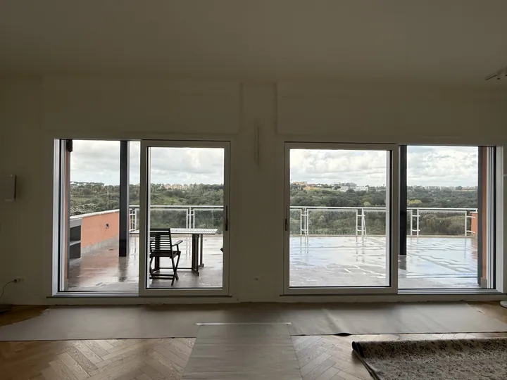 Soggiorno con due portefinestre nuove a tutta altezza aperte su una grande terrazza