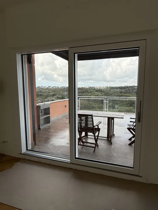 Portafinestra scorrevole aperta su una terrazza con vista sul verde
